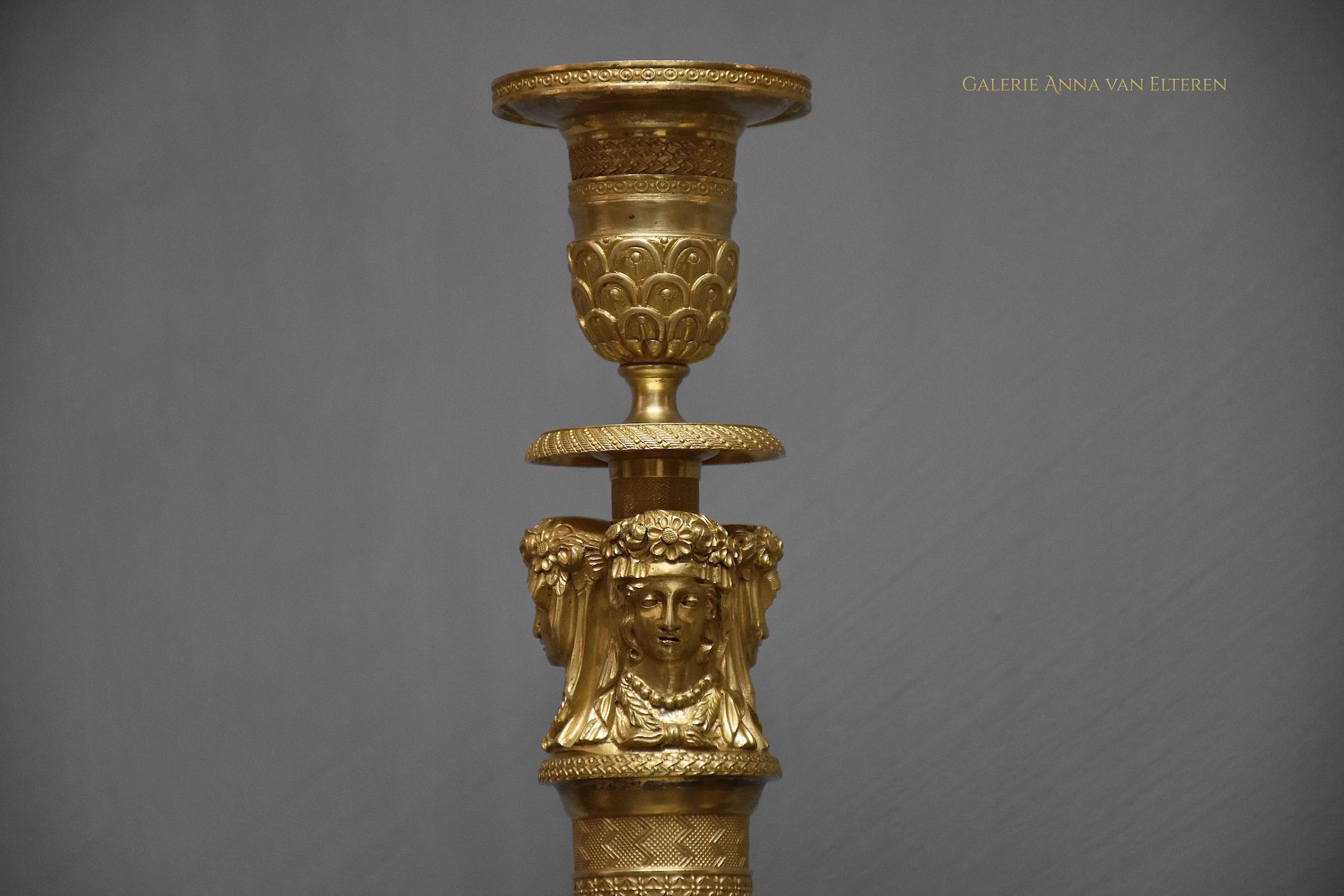 A pair of French Empire ormolu candlesticks