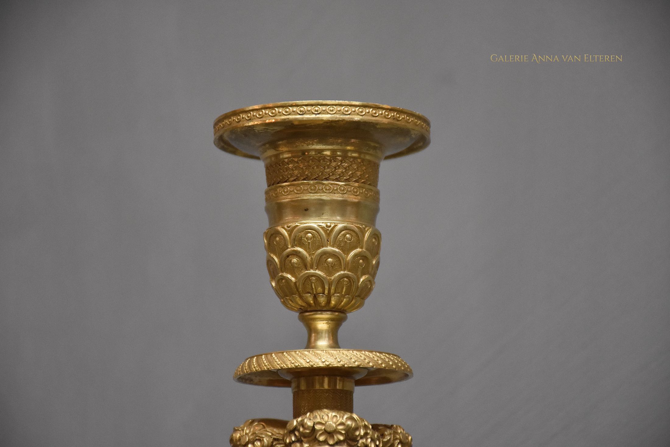 A pair of French Empire ormolu candlesticks