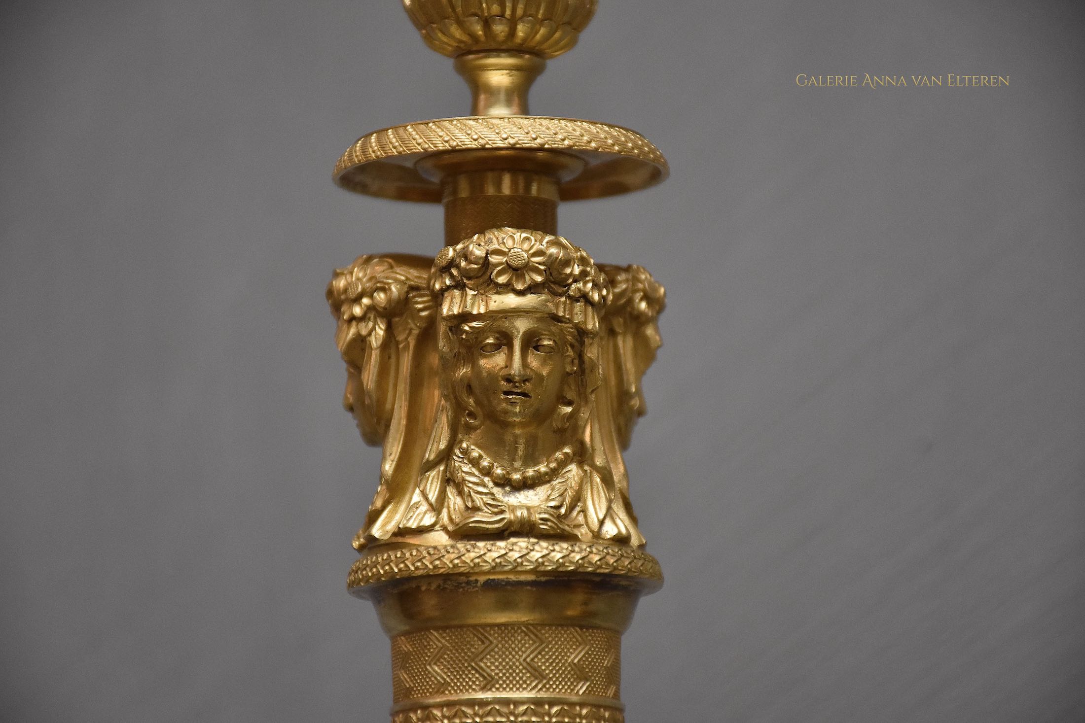 A pair of French Empire ormolu candlesticks